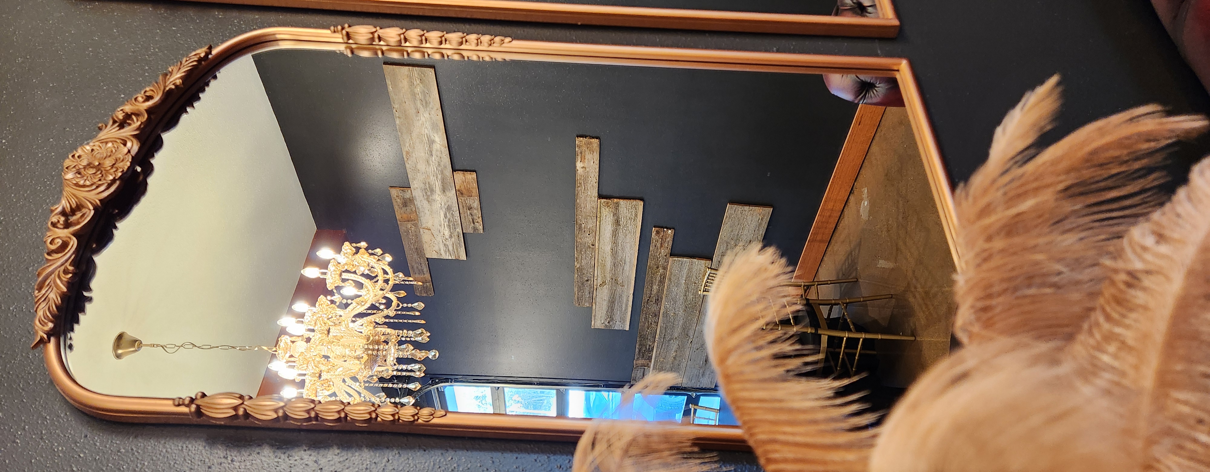 Ornate gold mirror reflecting a chandelier at The Back 30